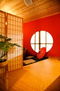 a room with a red wall and a round window at ゼロイン祇園三条 in Kyoto