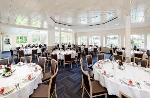 - une salle de banquet avec des tables et des chaises blanches dans l'établissement Hotel-Restaurant Haus Waldesruh, à Borken