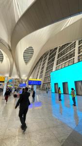 a group of people walking in an airport terminal at Shared Studio Bedspace Next to AUH Airport -Males- in Abu Dhabi