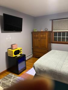 Jays Ranch Hamden في هامدين: غرفة نوم مع سرير وتلفزيون على الحائط