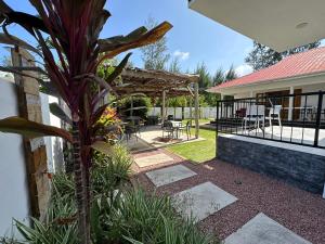 a garden with a pergola and a table and chairs at VincVilla in Praslin