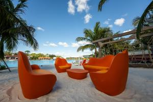 a group of orange chairs sitting on the sand near a pool at Evermore Orlando Resort in Orlando