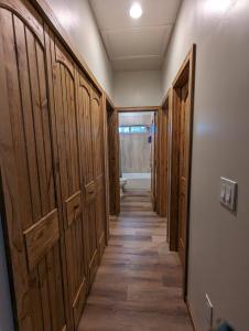 un couloir avec des portes en bois et un long couloir dans l'établissement Cozy Cottage 2BD/2BA, 2 Covered Decks, Patio Dinning, Newly Built!, à Pinetop-Lakeside
