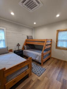 派托普湖畔的住宿－Cozy Cottage 2BD/2BA, 2 Covered Decks, Patio Dinning, Newly Built!，一间卧室配有两张床和一张双层床。