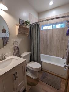 uma casa de banho com um WC, uma banheira e um lavatório. em Cozy Cottage 2BD/2BA, 2 Covered Decks, Patio Dinning, Newly Built! em Pinetop-Lakeside