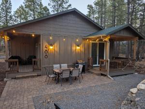 une cabine avec une table et des chaises sur une terrasse dans l'établissement Cozy Cottage 2BD/2BA, 2 Covered Decks, Patio Dinning, Newly Built!, à Pinetop-Lakeside