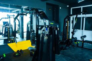 - une salle de sport avec un groupe de machines dans une pièce dans l'établissement Viswa Service Apartment, à Madurai