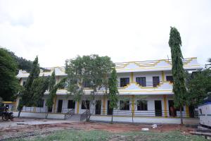 un gran edificio blanco con árboles delante de él en Grand Pacific en Pondicherry