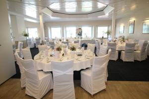 a large room with white tables and white chairs at Hotel-Restaurant Haus Waldesruh in Borken