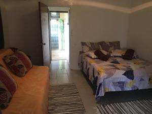 um quarto com uma cama e um sofá em Iaoraboraborahouse TEREIA em Bora Bora