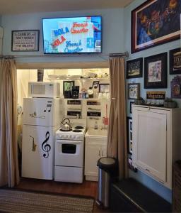 cocina con electrodomésticos blancos y TV en la pared en Jazzy Studio in a GREAT Location en Nueva Orleans