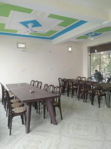 Habitación con mesas y sillas de madera y techo. en Haridwar and kedarnath dharmshala en Haridwār