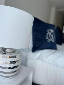 Suite Palace Exclusive lakeside loft في بايبا: طاولة مع مصباح ومخدة على السرير