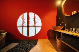a bathroom with a red wall with a round window at ゼロイン祇園三条 in Kyoto +37 photos