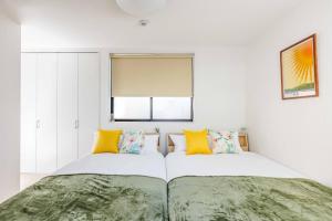 a bedroom with two beds and a window at エクセルシア in Osaka
