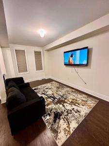 a living room with a couch and a flat screen tv at C&M LUXURY HOME in Brampton