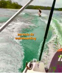 a man riding a wave on a boat in the water at Hermosa habitación 203 deluxe GC in Guatapé
