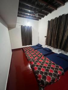 Zimmer mit 2 Betten und roten Blumen darauf in der Unterkunft ZenHost in Kalpatta