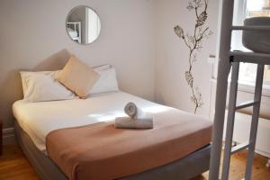 Dormitorio pequeño con cama con espejo en YHA Port Elliot Beach House, en Port Elliot