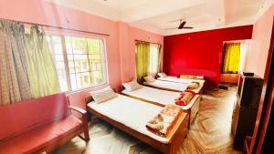 two beds in a room with a red wall at Hotel Vishal in Siliguri