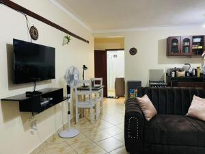ein Wohnzimmer mit einem Sofa und einem Esszimmer in der Unterkunft Muggiez Olive, Kira in Kampala