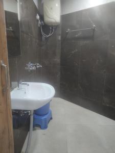 ein Bad mit einem Waschbecken und einer schwarzen Wand in der Unterkunft Rishikesh by prithvi yatra hotels dharmshala in Rishikesh