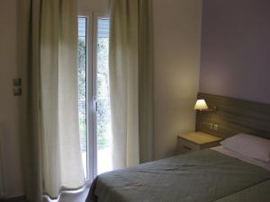 A bed or beds in a room at Alexandros