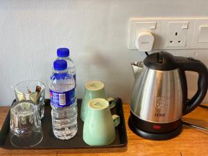 a tray with a tea kettle and a bottle of water at Super 8 Hotel Alor Setar in Alor Setar