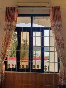 een raam met gordijnen in een kamer bij Green Hill Guest House in Ba Hòn