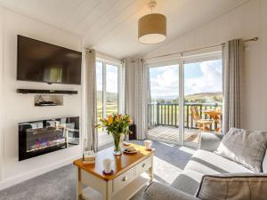 a living room with a couch and a tv and a balcony at 2 Bed in Portree 87578 in Portree