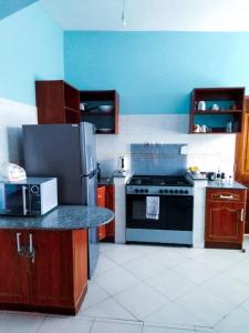 a kitchen with a refrigerator and a stove top oven at Lux Suites Sunset Furnished Apartments in Mombasa