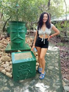 a woman standing next to a green statue at Akein Jungle Resort - Sigiriya in Sigiriya