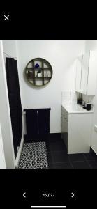 a bathroom with a mirror and a black and white tile floor at Cottage on cork - Steadman cottage in Winton