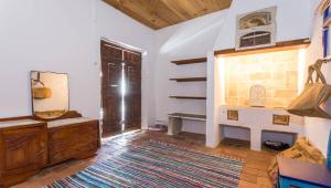 a living room with a wooden dresser and a window at Casa do Levante in Olhão