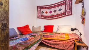 a bedroom with two beds and a rug on the wall at Casa do Levante in Olhão