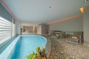 a swimming pool in a hotel with chairs and tables at Havana Nha Trang Hotel in Nha Trang