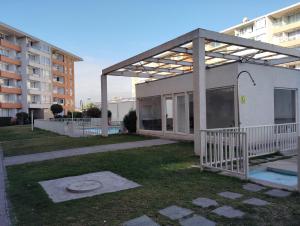 un edificio blanco con techo de metal en un patio en Departamente 2 habitaciones 2 baños a pasos playas supermercado y plaza de armas, en La Serena