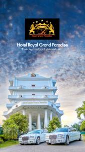 dos autos estacionados frente a un hotel Gran Paraíso Real en Hotel Royal Grand Paradise, en Kelaniya