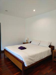 een slaapkamer met een bed met witte lakens bij แกรนด์ฮิลล์ เฮาส์ Grandhill house in Hua Hin