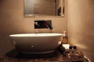 ein Badezimmer mit einem großen weißen Waschbecken auf der Theke in der Unterkunft HOTEL 16 AVENUE in Kalkutta