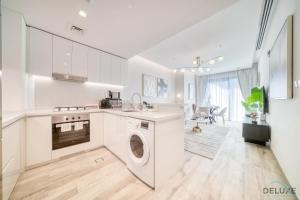 a white kitchen with a washer and dryer in it at Convenient 1BR at Ahad Residences Business Bay by Deluxe Holiday Homes in Dubai