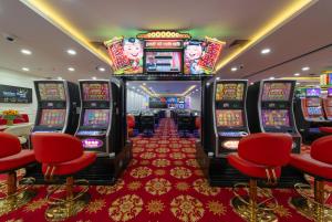 um casino com cadeiras vermelhas e slot machines em Havana Nha Trang Hotel em Nha Trang