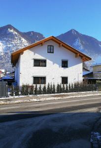a white building on the side of a street with mountains at Ferienwohnung Wiadahoam in Marquartstein