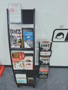 una mensola piena di videogiochi accanto a un muro di Ekonomy Hotel Myeongdong Premier a Seul