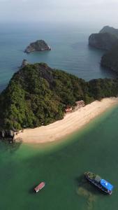 two boats in the water next to an island at Cat Ba Seoul 2 Hotel & Apartment in Cat Ba +59 photos