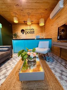 eine Lobby mit einem Tisch und einer Blumenvase in der Unterkunft Pousada Point in Aracati