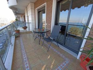 a balcony with a table and chairs on a building at Seafront Family Apartment & free parking, the Cruiseflat in Thessaloniki