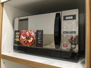 a microwave oven with a picture of a pizza at Sofiamuslim Homestay Putrajaya in Putrajaya