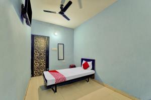 a bed in a room with a ceiling fan at Super OYO Flagship Glad Guest House in Patna