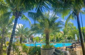 a swimming pool with palm trees in a resort at Fla Village in Phú Quốc